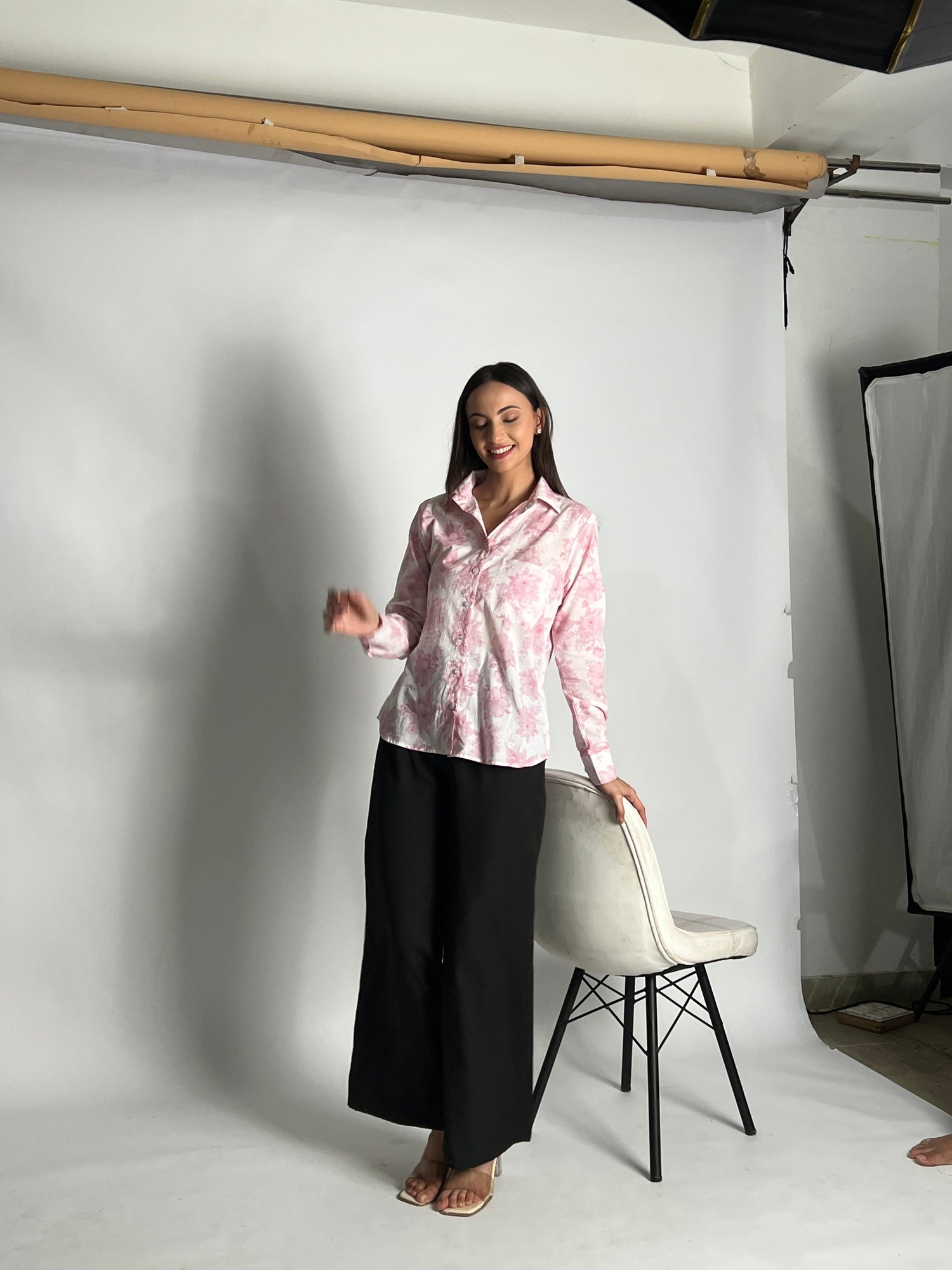 A Women wearing a floral pink print shirt that can be worn from desk to dinner day and night all across india one that is available from Small to 4XL and cab be made custom measurements. All Day comfort in bright summer heat. Affordable Accessible Luxury